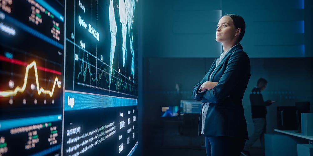 Woman looking at digital screens with her arms folded