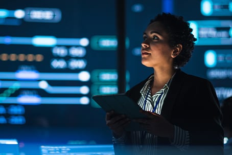 Female Government Employee Uses Tablet Computer in System Control Monitoring Center